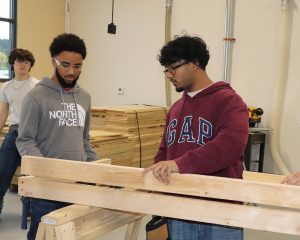 2 boys measuring wood